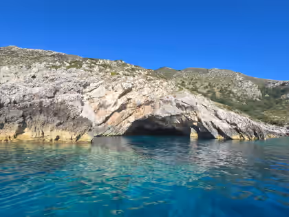 Rock arch and bright blue water at a Karaburun cave stop